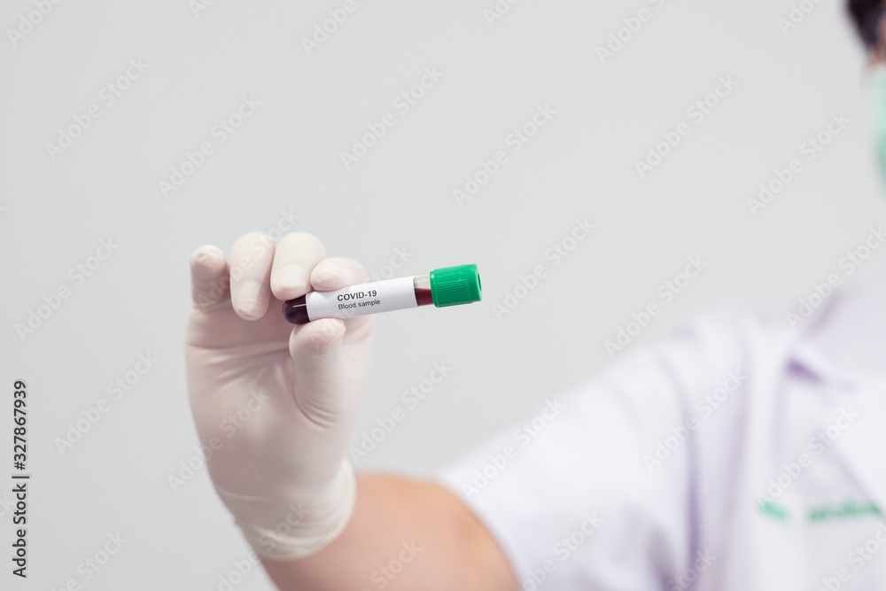 Asian male doctor holding Covid-19 Blood Sample on White Background Asian male doctor holding Covid-19 Blood Sample on White Background