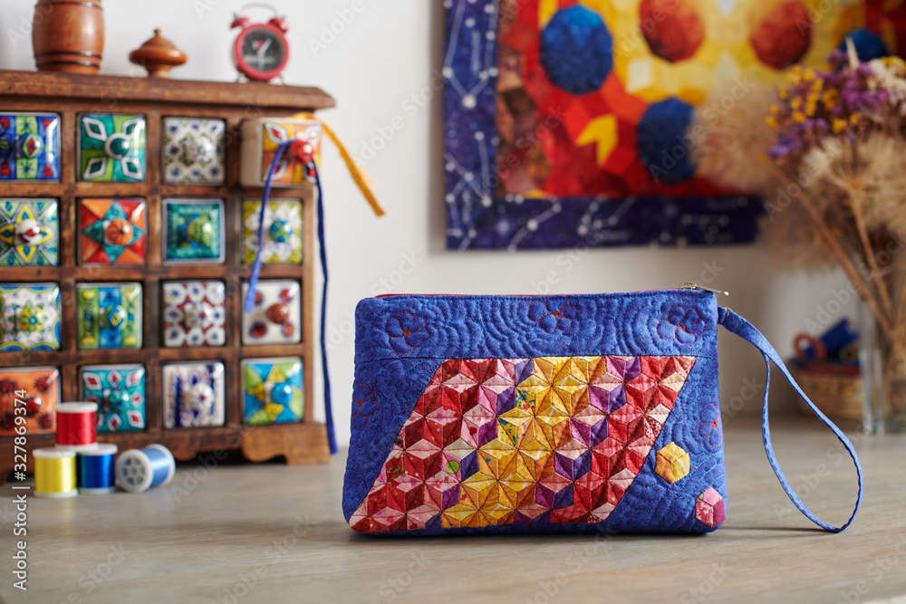 Patchwork handbag on the background.wooden mini chest with ceramic drawers Patchwork handbag on the background.wooden mini chest with ceramic drawers