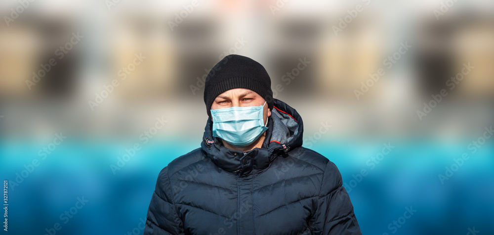 man in blue protective medical mask in the city against the background of the bridge and sky man in blue protective medical mask in the city against the background of the bridge and sky