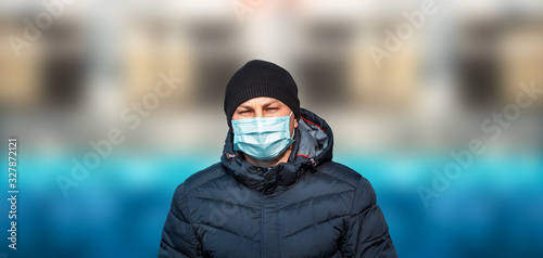man in blue protective medical mask in the city against the background of the bridge and sky