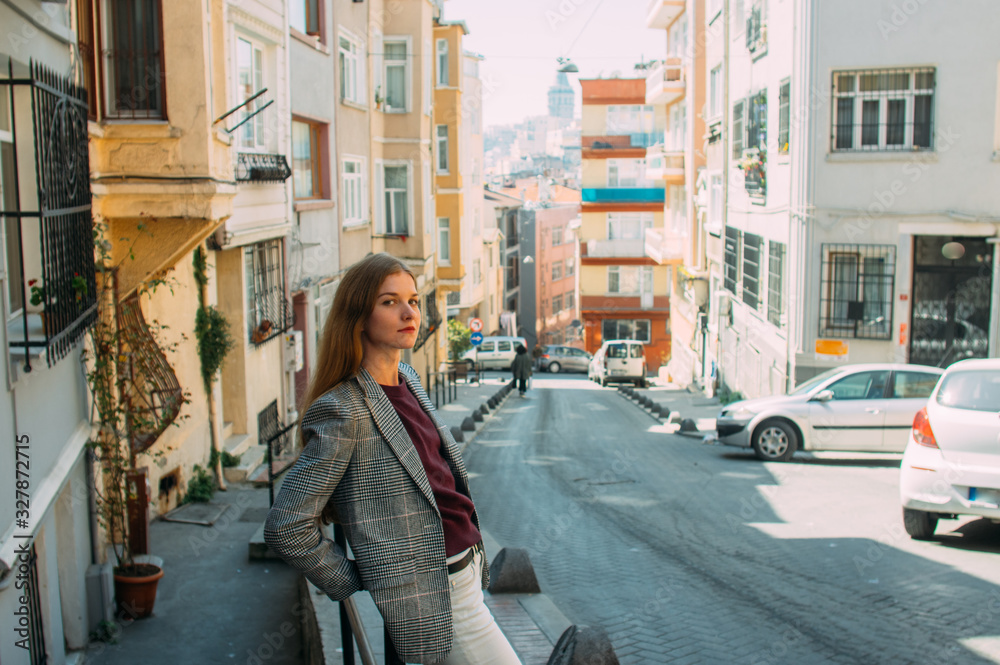 Beautiful girl with blond hair stands on old street of Istanbul