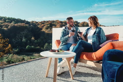 young couple celebrating the purchase of a new home. Smiling husband and wife with glasses of red wine in hands