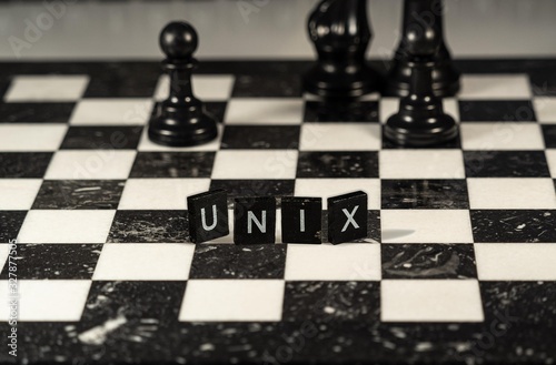 The concept of Unix represented by black and white letter tiles on a marble chessboard with chess pieces