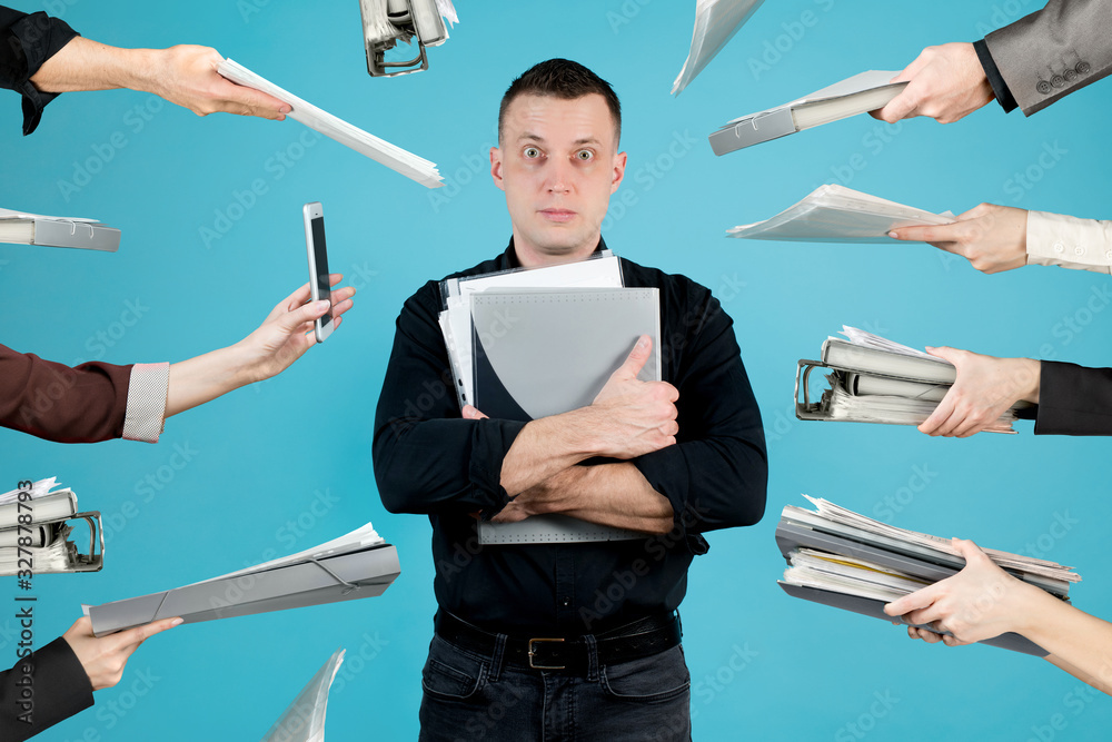 Φωτογραφία A office employee in a black shirt, hands pull folders, documents towards him