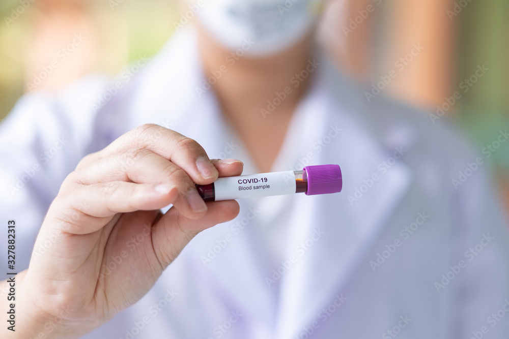 Asian male doctor holding Covid-19 Blood Sample on White Background Asian male doctor holding Covid-19 Blood Sample on White Background
