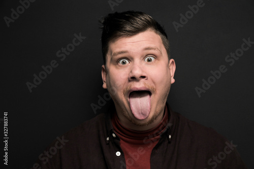 Portrait of young grimacing man isolated on gray background