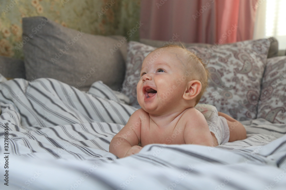 little chubby baby smiling while lying on the bed little chubby baby smiling while lying on the bed