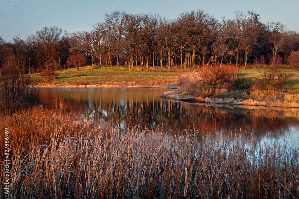 Sunset reflections on a small, secluded lake at the end of a calm November day. Sunset reflections on a small, secluded lake at the end of a calm November day.