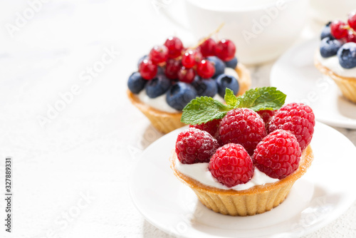 mini tarts with cream and berries and white background