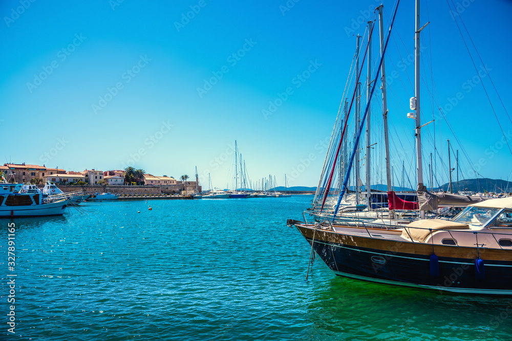 Boats in Alghero harbor on a clear springtime day