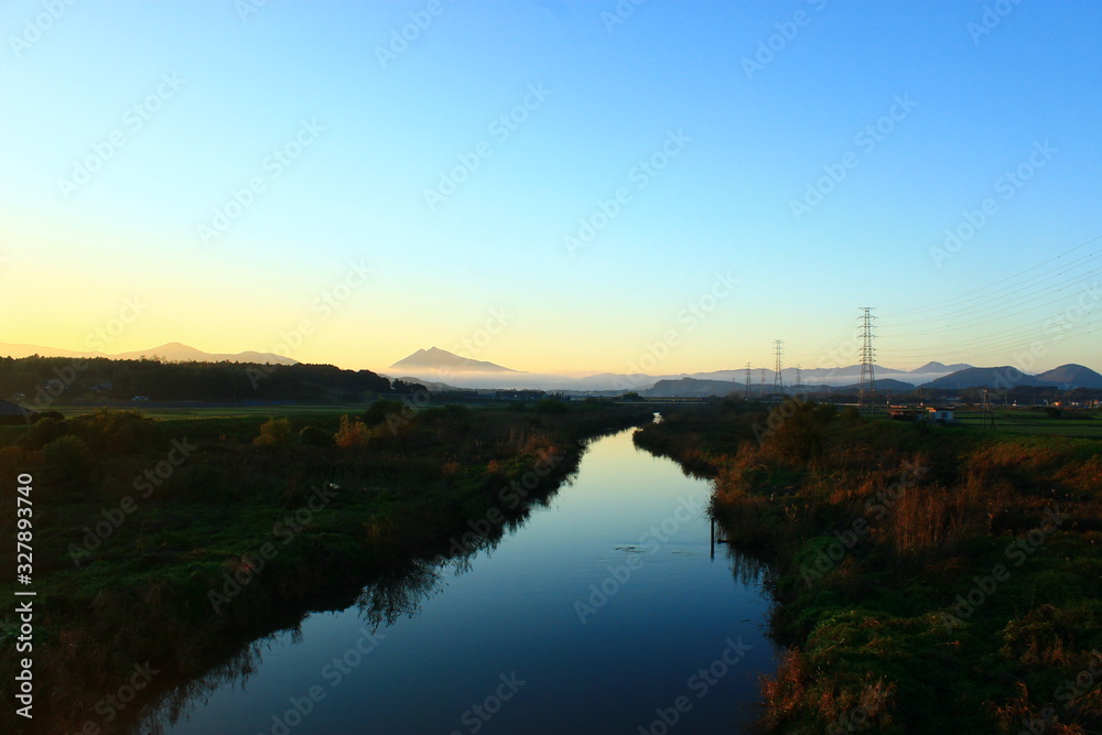 A Beautiful Twin Peak Mountain beyond a Quiet Stream at Sunset A Beautiful Twin Peak Mountain beyond a Quiet Stream at Sunset