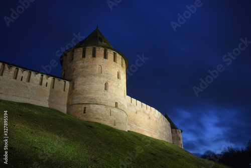 Night view from below on towers of an ancient fortress against the background of a night blue sky. Veliki Novgorod. Fedorovskaya and Metropolitan towers. Veliky Novgorod. Novgorod Kremlin. Old fortres