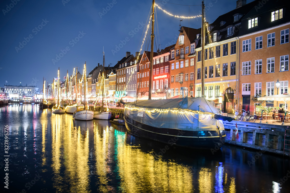 Fototapeta premium Evening view to boats in front of colourful old houses at Nyhavn harbour canal in Copenhagen, Denmark. February 2020