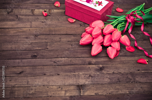 Flower. Tulip. Spring flowers. Bouquet of Red Tulips with Gift box on Dark wooden background. Greeting for Women, Mothers Day, Valentine's day. Copy space