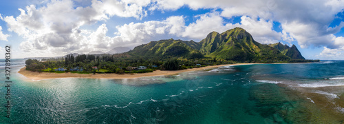 Aerial panoramic image off the coast over Tunnels beach on Hawaiian island of Kauai with Na Pali mountains behind