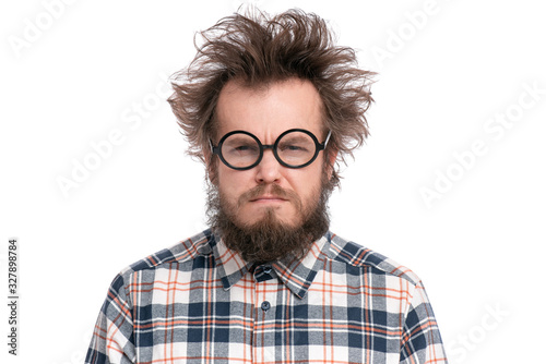 Crazy Serious Bearded Man in Eyeglasses with displeased Expression, isolated on white background. Guy in plaid shirt with funny Haircut looking with Anger. Emotions and signs concept