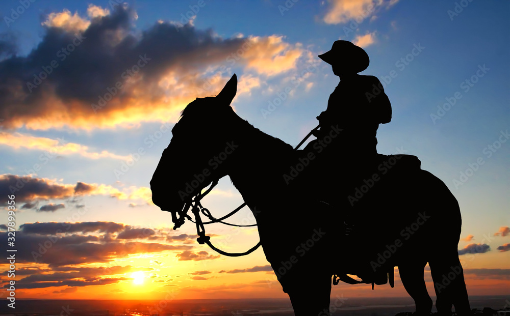 Cowoboy on a horse at sunet