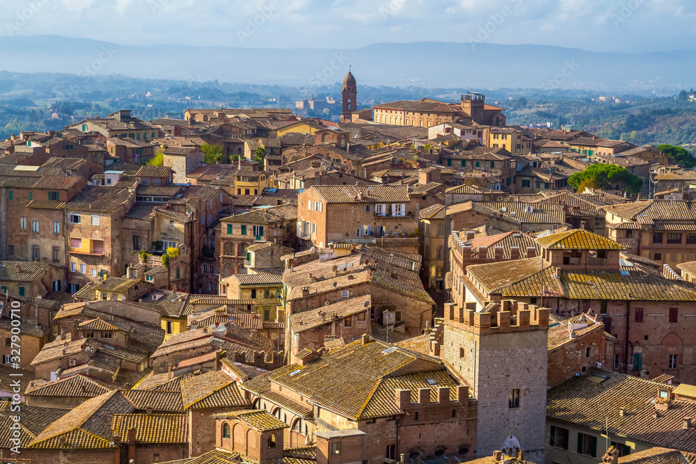 Panoramic view of Siena from The Torre del Mangia. Medieval houses are located on the hillsides, tuscan hills on the horizon. Pictorial cityscape. Tuscany, Italy.