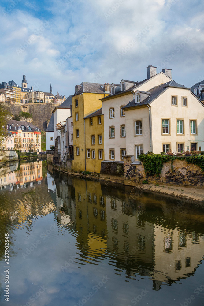 View of colorful living houses. Reflection in the Alzette river. Grund, Luxembourg. Beautiful spring nature. 