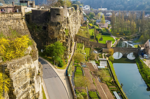 Panoramic view of old town of Luxembourg in the early spring. Ancient stone bridge over the Alzette river. Casemates du Bock, terraces with gardens.