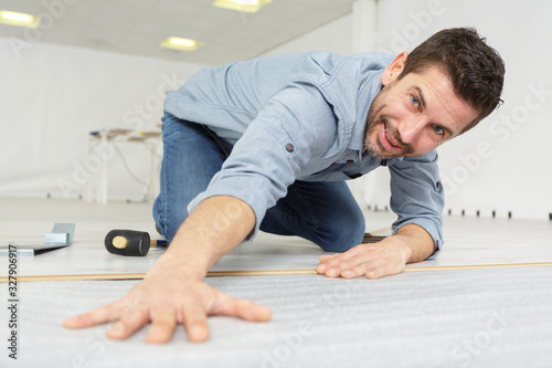a handyman laying new flooring © auremar