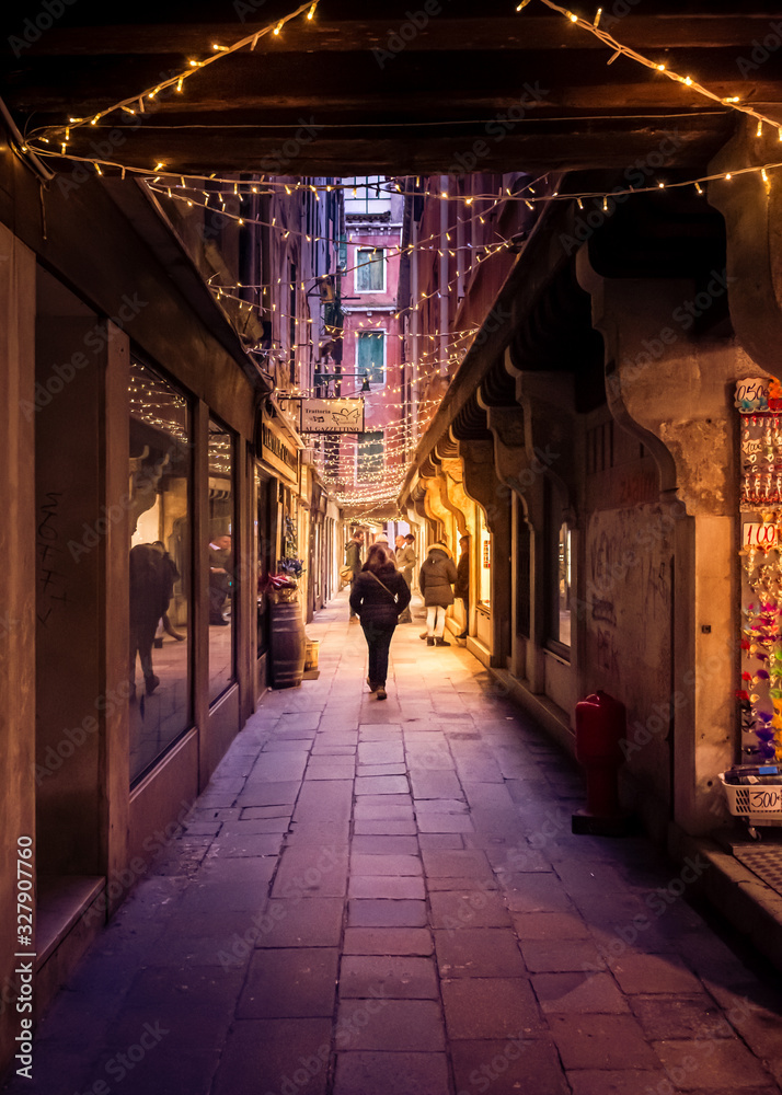 alley in venice with the warm yellow glow of christmas lights