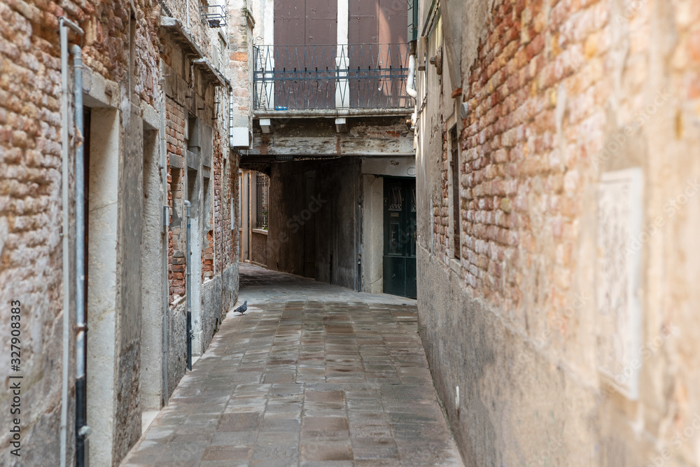 A narrow, deserted Venetian street. Copy space.