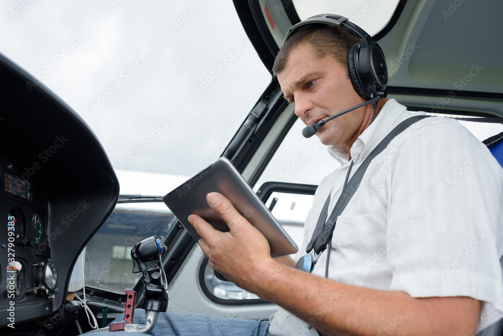 a pilot holding a tablet - obrazy, fototapety, plakaty 