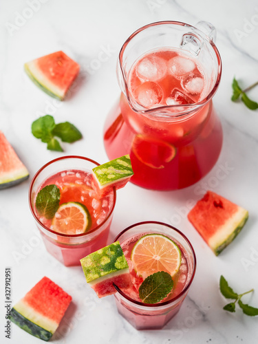 Watermelon cooler with lime, mint and ice. Perfect homemade watermelon drink in glasses on white background. Vertical