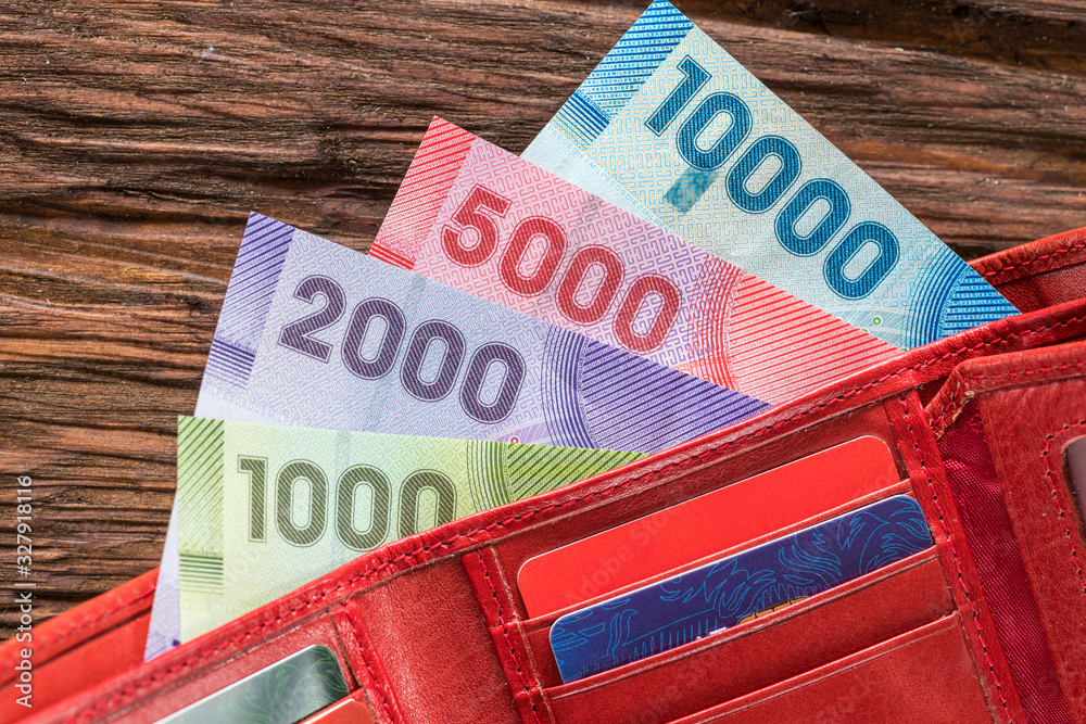 Obraz premium Chile money in the wallet on the wooden table top.