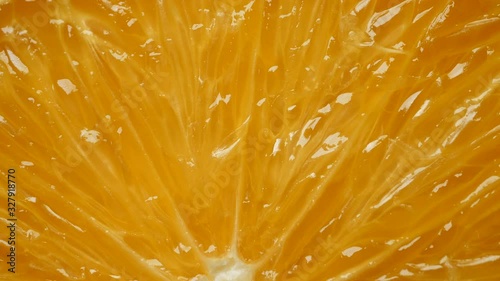 Rotating fresh yellow organic orange slice in extreme close up macro