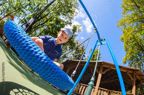 Boy on swing in park, happy...