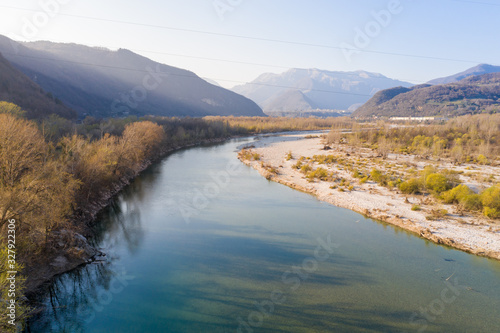 Aerial view at sunset of river with distant mountains in northern Italy