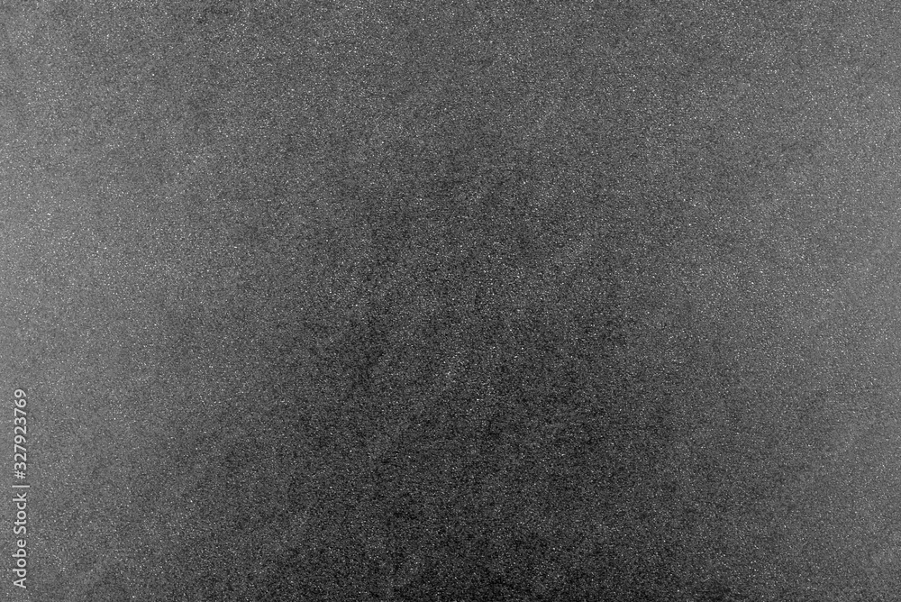 Fototapeta premium Black and white background made of real black paper with white dots, illuminated by a soft light on the sides.