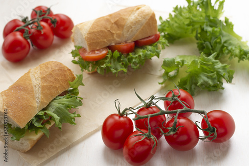 sandwiches with lettuce, tomatoes and cheese, on a light background, with cherry tomatoes on a branch