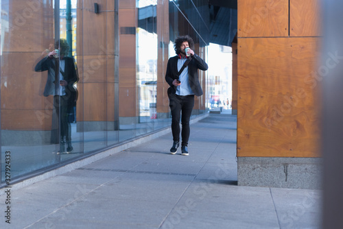 Portrait Of young Businessman  Outside Office. Meeting Concept. Man Walking and drinking coffe, going to the office. © as-artmedia