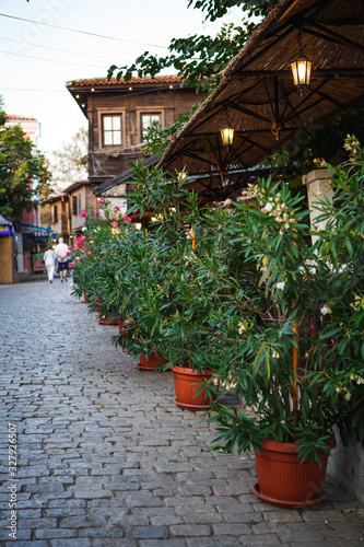 Fototapeta Naklejka Na Ścianę i Meble -  Cobblestone and stone-tiled streets of the old tourist part of the city of Bulgaria. Typical Bulgarian houses made of stone and wood in old Sozopol, Nessebar, Veliko Tarnovo