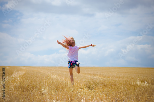 little child having fun in agricultural field backview