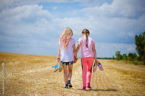children walking in golden fields together hand in hand