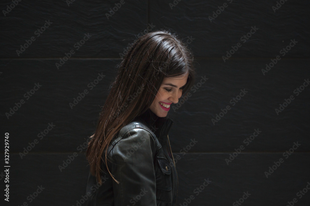 Beautiful brunette standing in front of black wall Beautiful brunette standing in front of black wall