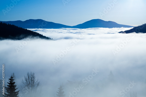 Thick white fog among mountain peaks