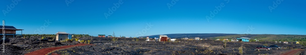 Panoramic view of a small village on a field of lava flows in Big Island Hawaii.