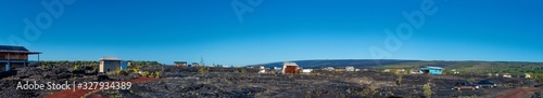 Panoramic view of a small village on a field of lava flows in Big Island Hawaii.