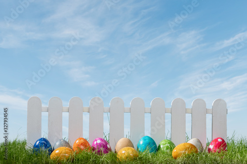 Photography Spring grass and wooden fence with easter eggs on cloudy sky