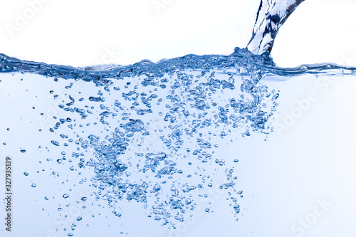 On white background which is filled with water, water is pouring and many bubbles rise from bottom to top