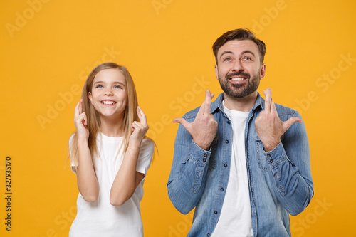 Bearded man have fun with child baby girl. Father, little kid daughter isolated on yellow background. Love family day parenthood childhood. Wait for special moment keeping fingers crossed making wish.