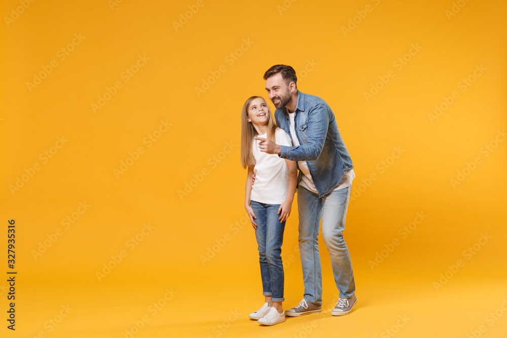 Excited bearded man in casual clothes have fun with child baby girl. Father little kid daughter isolated on yellow background. Love family parenthood childhood concept. Pointing index finger aside. Excited bearded man in casual clothes have fun with child baby girl. Father little kid daughter isolated on yellow background. Love family parenthood childhood concept. Pointing index finger aside.