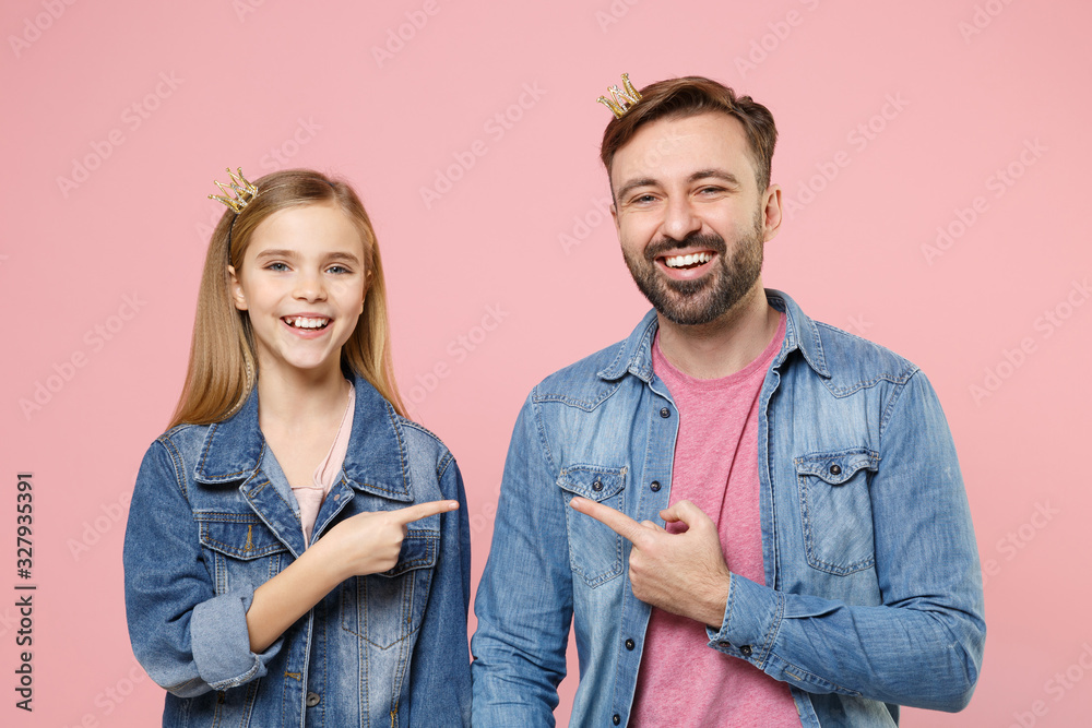 Funny bearded man with child baby girl. Father little kid daughter isolated on pastel pink background. Love family parenthood childhood concept. Wearing crowns pointing index fingers at each other. Funny bearded man with child baby girl. Father little kid daughter isolated on pastel pink background. Love family parenthood childhood concept. Wearing crowns pointing index fingers at each other.
