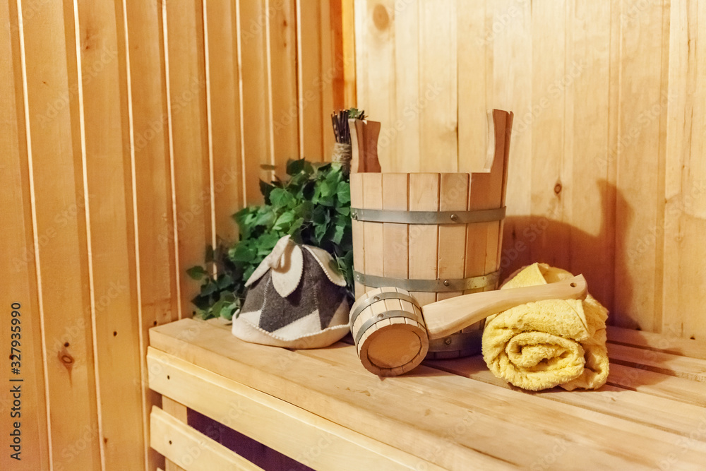 Interior details Finnish sauna steam room bathhouse with traditional sauna accessories basin birch broom scoop felt hat towel Photos Adobe Stock