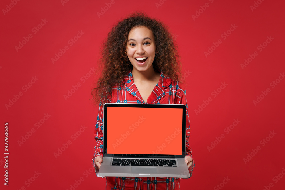 Excited young african american girl in pajamas homewear rest at home  isolated on red background. Relax